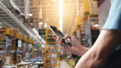 Lager - Mann mit Smartphone und Logisitik-Apps