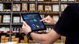 Mann im Lager, der online über ein Tablet Prozesse in Lager und Logistik managt, mit Link zu passenden SAP-Lösungen für diese Bereiche.